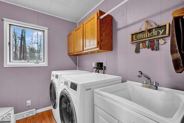 10495 Deer Run Rd, Poland, IN 47868 - washroom with visible vents, a sink, light wood-type flooring, washer and dryer, and cabinet space