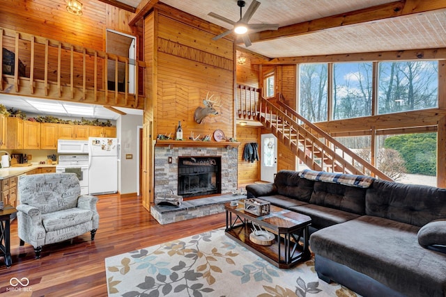 10495 Deer Run Rd, Poland, IN 47868 - living area featuring beam ceiling, a ceiling fan, wood finished floors, wood walls, and a fireplace