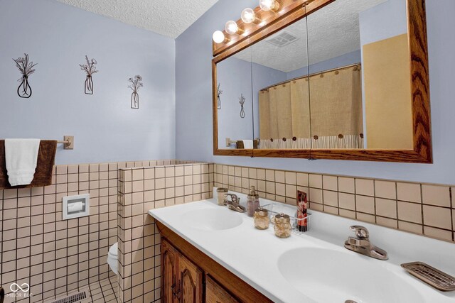 10495 Deer Run Rd, Poland, IN 47868 - bathroom with visible vents, a sink, a textured ceiling, and tile walls