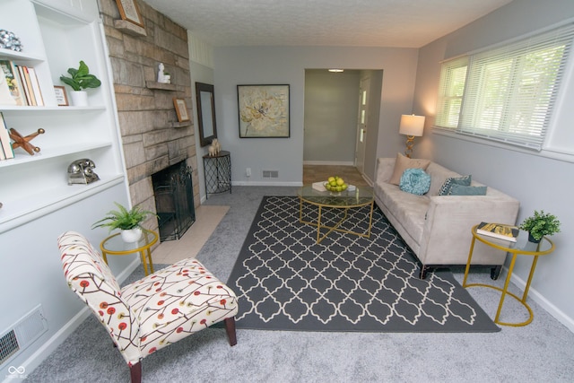 3140 Bonham Dr, Indianapolis, IN 46222 - living room with a stone fireplace, carpet floors, baseboards, and a textured ceiling
