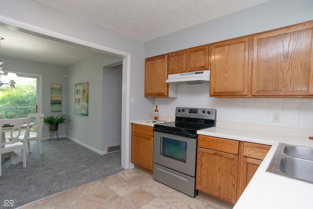 3140 Bonham Dr, Indianapolis, IN 46222 - kitchen with stainless steel electric stove, under cabinet range hood, a chandelier, light carpet, and light countertops