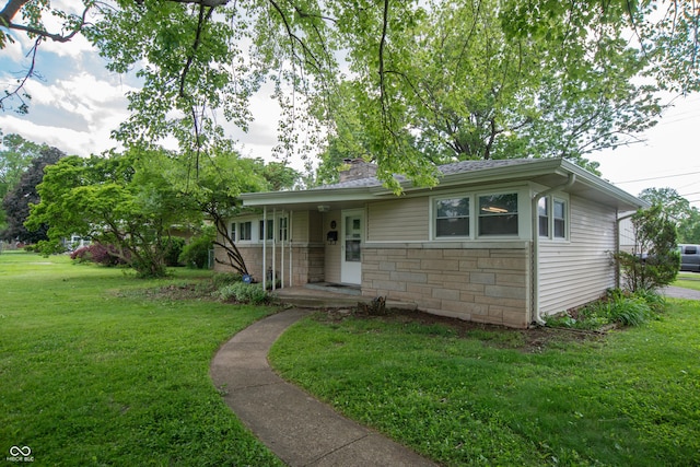 3140 Bonham Dr, Indianapolis, IN 46222 - view of front facade with a front lawn, stone siding, and a chimney