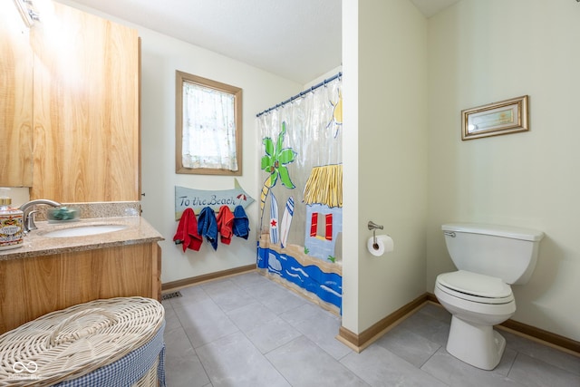 bathroom featuring baseboards, toilet, and vanity