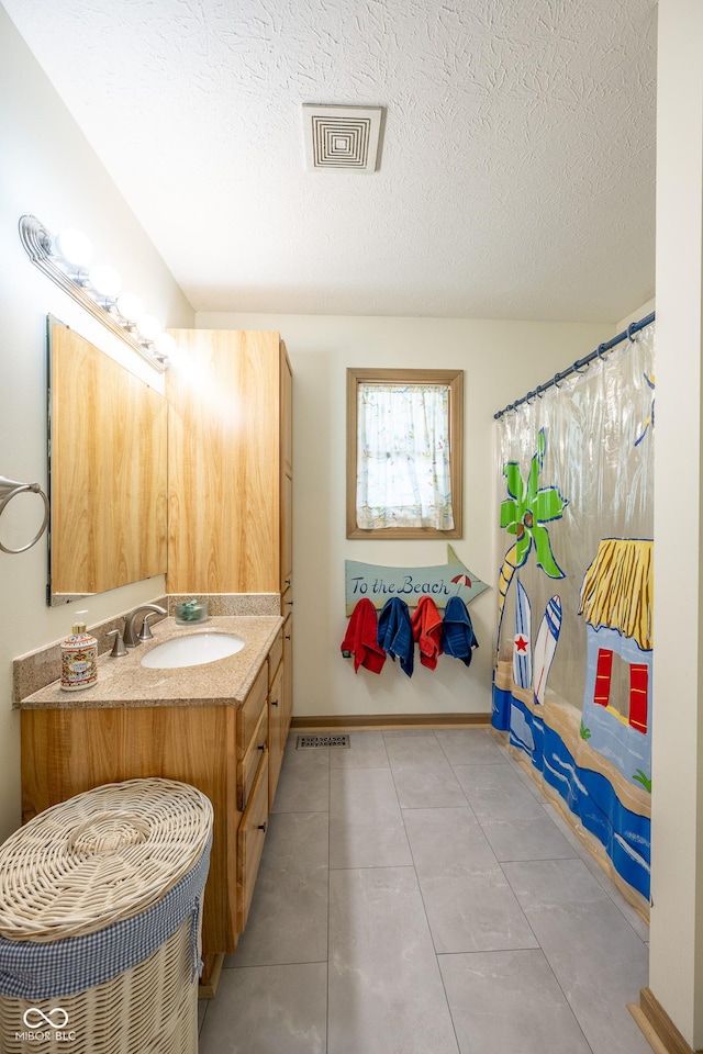 full bathroom with a textured ceiling, vanity, a shower with curtain, tile patterned flooring, and visible vents