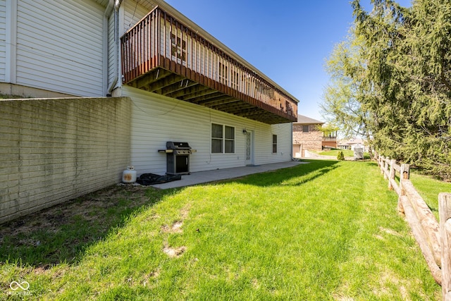 rear view of house with a lawn, fence, and a deck