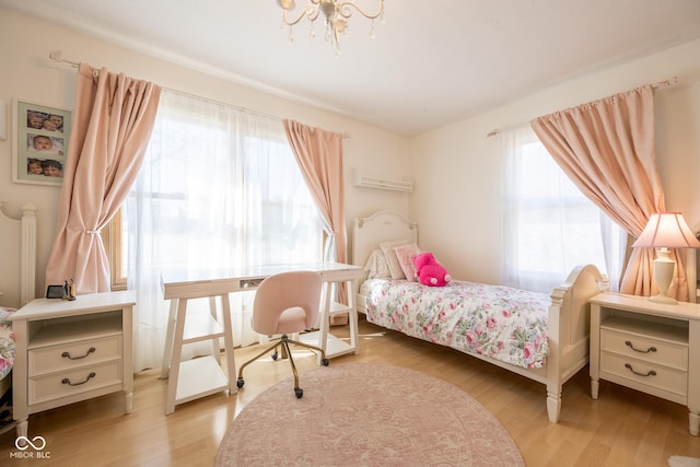 bedroom featuring wood finished floors, a chandelier, and multiple windows