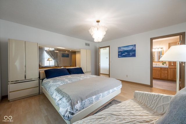 bedroom with light wood-type flooring, baseboards, ensuite bath, a notable chandelier, and visible vents