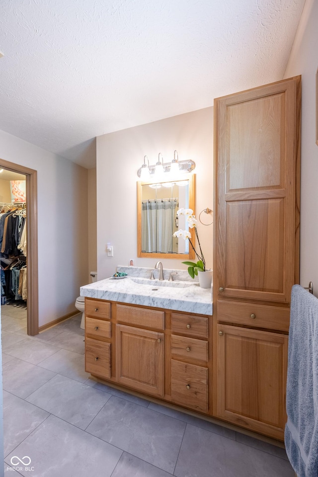 bathroom featuring vanity, tile patterned floors, and a textured ceiling