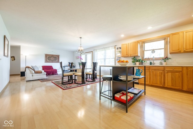 kitchen featuring light wood finished floors, light countertops, and a sink