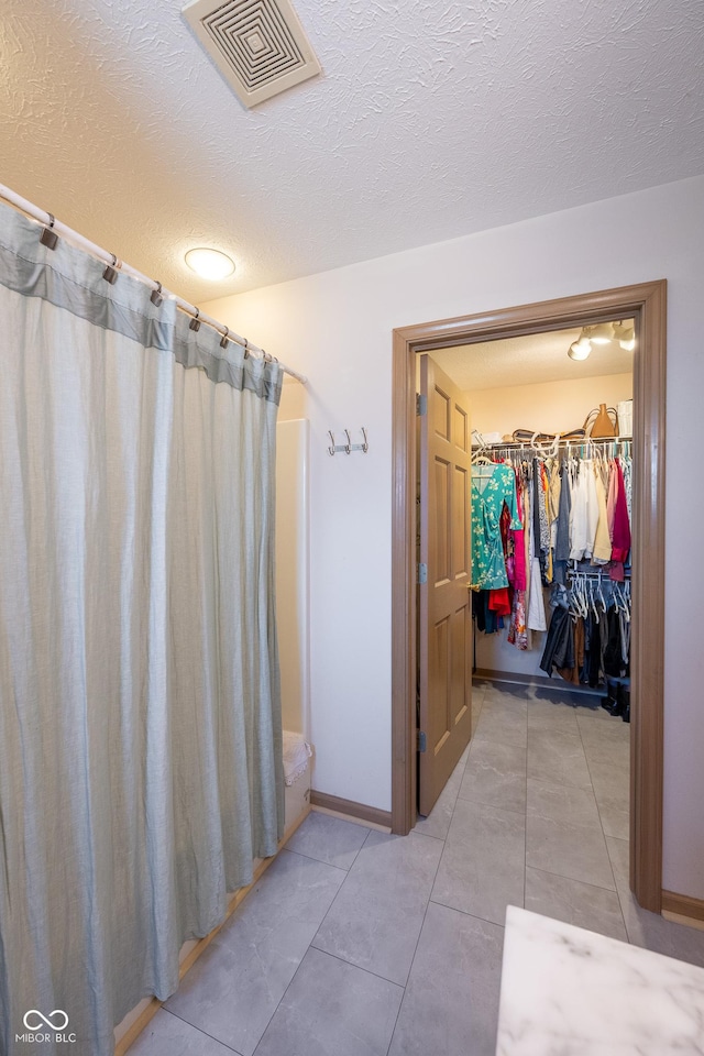 full bathroom featuring curtained shower, visible vents, and tile patterned flooring