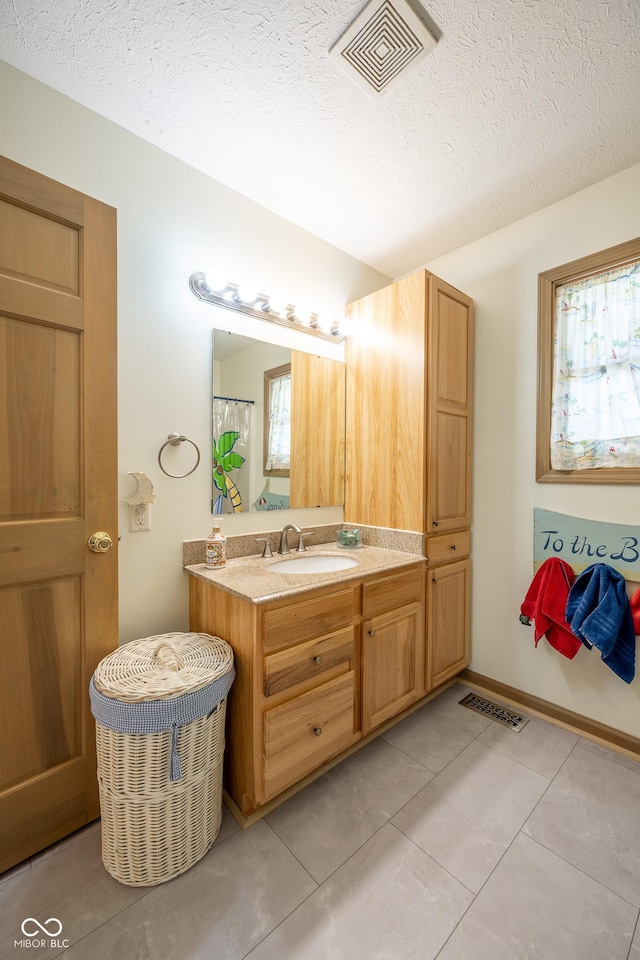 full bath featuring tile patterned floors, visible vents, a textured ceiling, and vanity