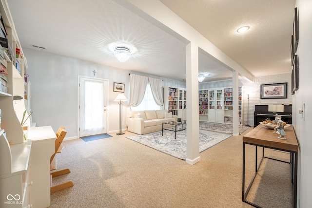 carpeted living area featuring visible vents and baseboards
