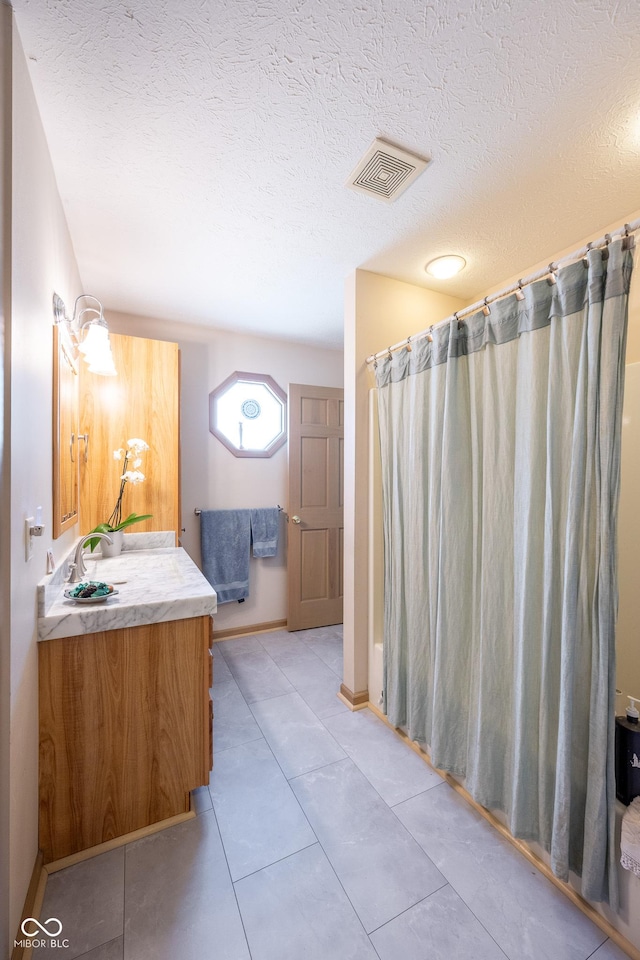 bathroom featuring tile patterned floors, a textured ceiling, visible vents, curtained shower, and vanity