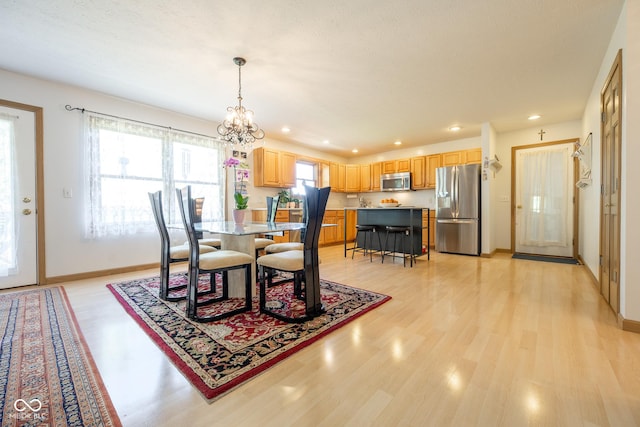 dining space with a chandelier, light wood-style flooring, baseboards, and recessed lighting