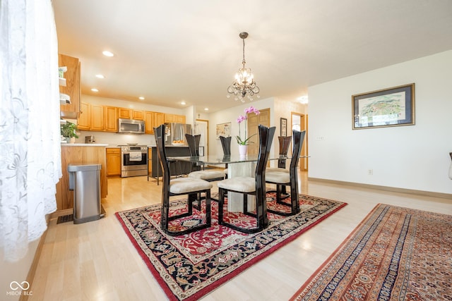 dining area with baseboards, an inviting chandelier, light wood finished floors, and recessed lighting