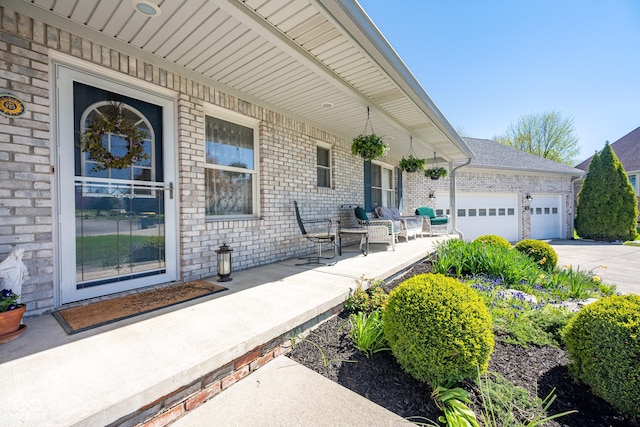 view of patio featuring an attached garage, covered porch, and concrete driveway
