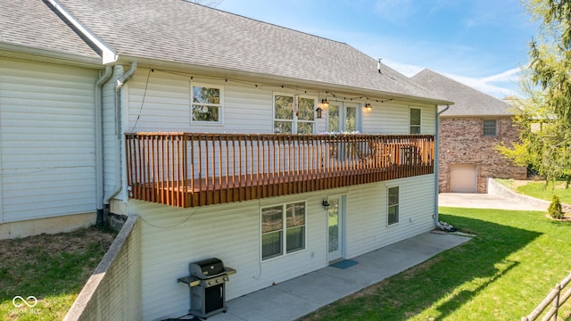 rear view of property featuring a wooden deck, a yard, a patio, and a shingled roof