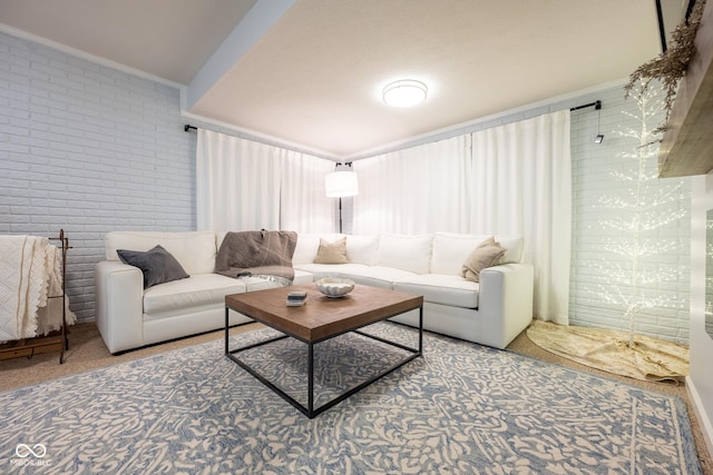 carpeted living area featuring brick wall