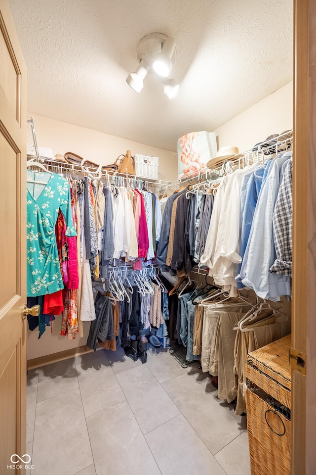 walk in closet with light tile patterned floors