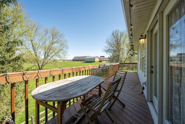 wooden deck with a lawn and outdoor dining space