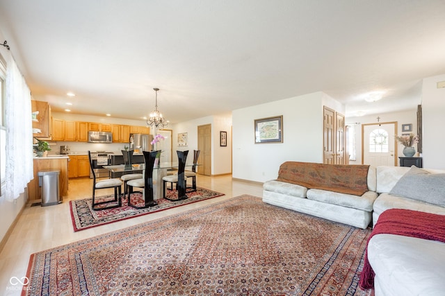 living area with light wood-type flooring, baseboards, recessed lighting, and a notable chandelier