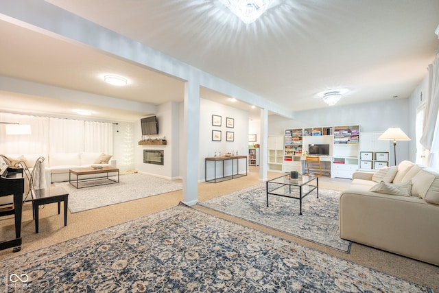 carpeted living area with baseboards and a fireplace