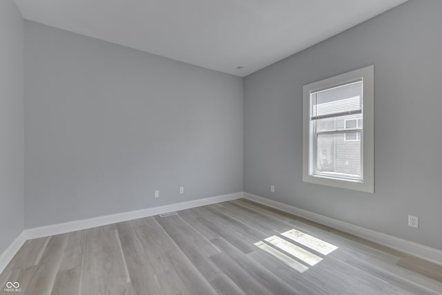 spare room with light wood finished floors and baseboards
