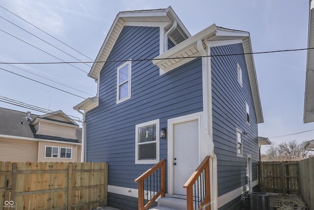 back of property with entry steps, fence, and central air condition unit