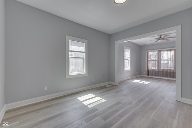 unfurnished room featuring light wood-style flooring, baseboards, and ceiling fan