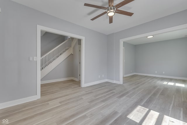 spare room with light wood-style flooring, ceiling fan, and baseboards