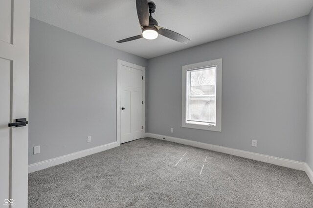 empty room with ceiling fan, baseboards, and carpet floors