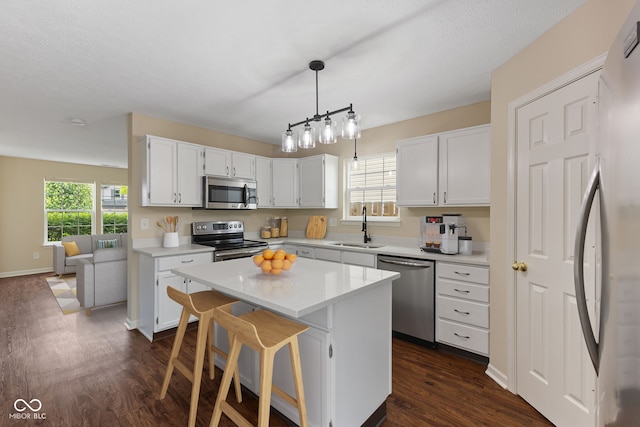 518 Carthage Cir, Westfield, IN 46074 - kitchen featuring stainless steel appliances, a sink, dark wood finished floors, a kitchen island, and white cabinets