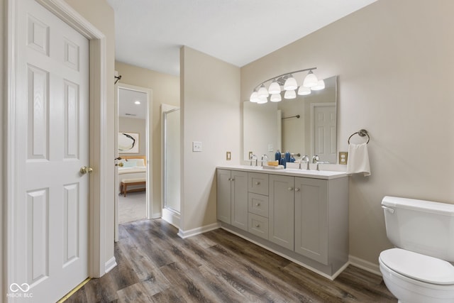 518 Carthage Cir, Westfield, IN 46074 - bathroom featuring toilet, wood finished floors, double vanity, and baseboards