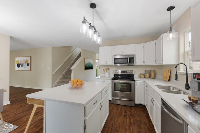 518 Carthage Cir, Westfield, IN 46074 - kitchen with stainless steel appliances, a sink, a kitchen island, light countertops, and white cabinets