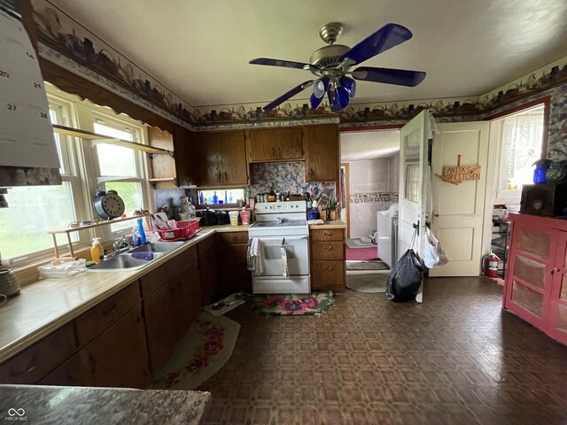 kitchen with a sink, white electric range oven, ceiling fan, and light countertops