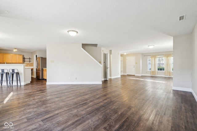 10303 Memorial Knoll Dr, Indianapolis, IN 46234 - unfurnished living room featuring dark wood-style floors, baseboards, visible vents, and a textured ceiling