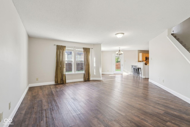 10303 Memorial Knoll Dr, Indianapolis, IN 46234 - unfurnished living room featuring dark wood-style flooring, a wealth of natural light, stairway, and a chandelier