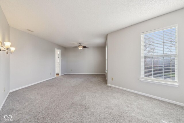 10303 Memorial Knoll Dr, Indianapolis, IN 46234 - empty room featuring baseboards, a textured ceiling, carpet floors, visible vents, and ceiling fan with notable chandelier
