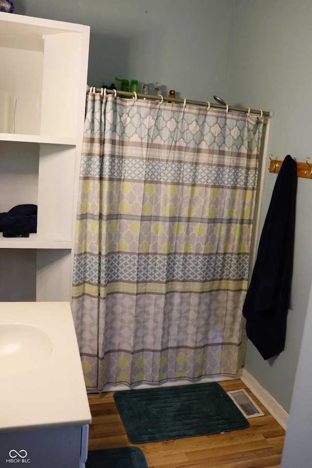 full bathroom featuring visible vents, a shower with curtain, vanity, and wood finished floors