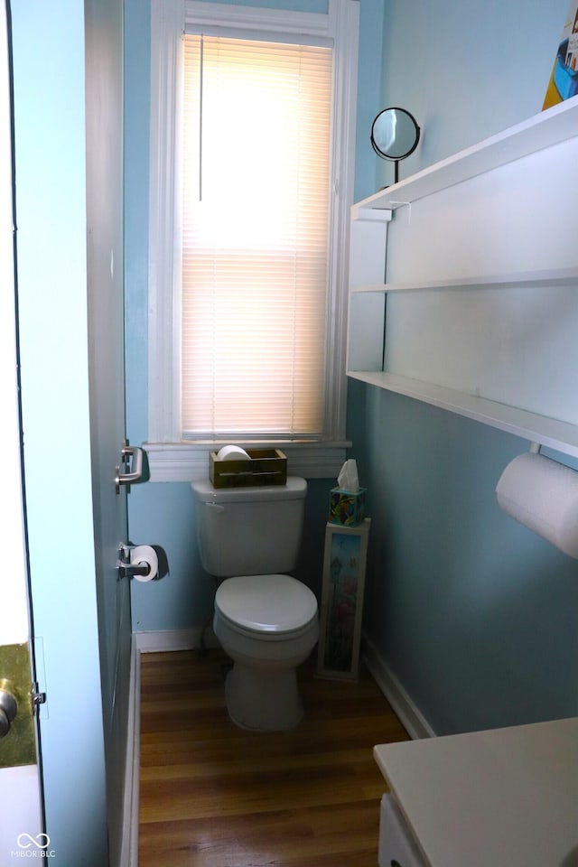 bathroom with baseboards, toilet, and wood finished floors