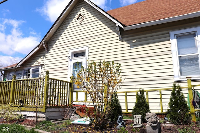 rear view of house featuring roof with shingles