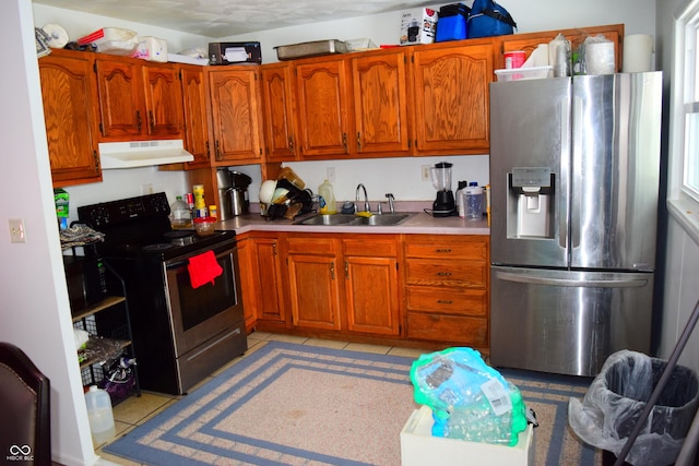 4107 Eisenhower Dr, Indianapolis, IN 46254 - kitchen with light tile patterned floors, light countertops, under cabinet range hood, appliances with stainless steel finishes, and a sink