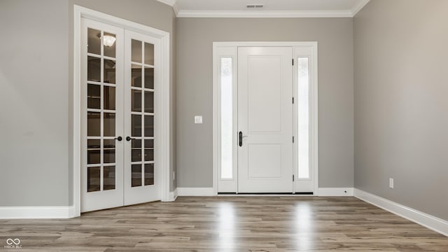 528 Dylan Dr, Carmel, IN 46032 - foyer entrance featuring french doors, crown molding, wood finished floors, and baseboards