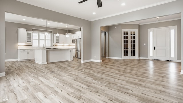 528 Dylan Dr, Carmel, IN 46032 - unfurnished living room with a ceiling fan, light wood-type flooring, baseboards, ornamental molding, and recessed lighting
