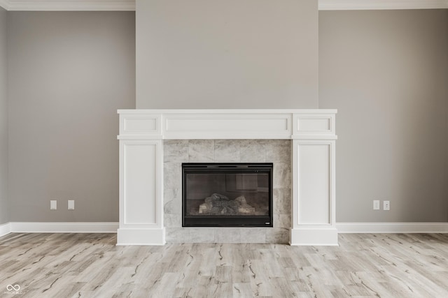 528 Dylan Dr, Carmel, IN 46032 - detailed view of wood finished floors, crown molding, baseboards, and a tile fireplace