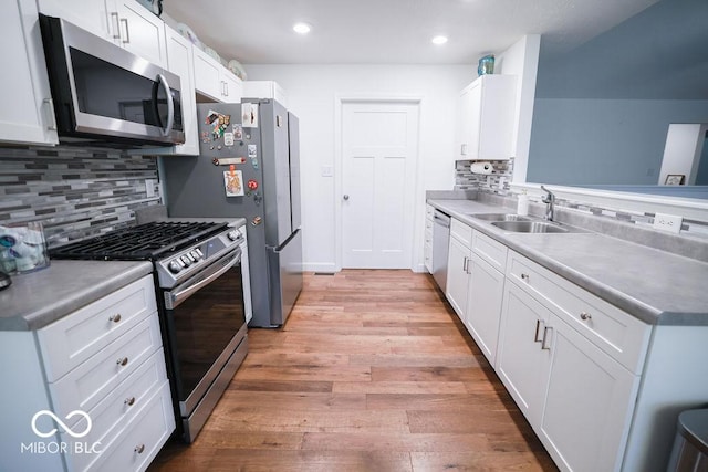 8917 N Old State Road 37, Bloomington, IN 47408 - kitchen with white cabinetry, backsplash, appliances with stainless steel finishes, light wood finished floors, and a sink
