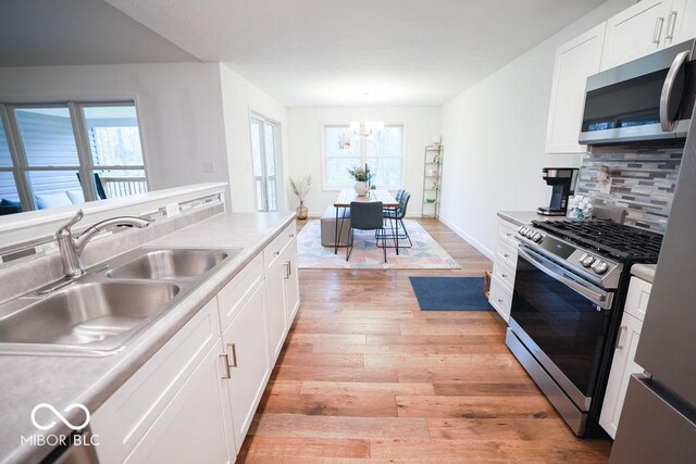 8917 N Old State Road 37, Bloomington, IN 47408 - kitchen with a sink, appliances with stainless steel finishes, plenty of natural light, and an inviting chandelier
