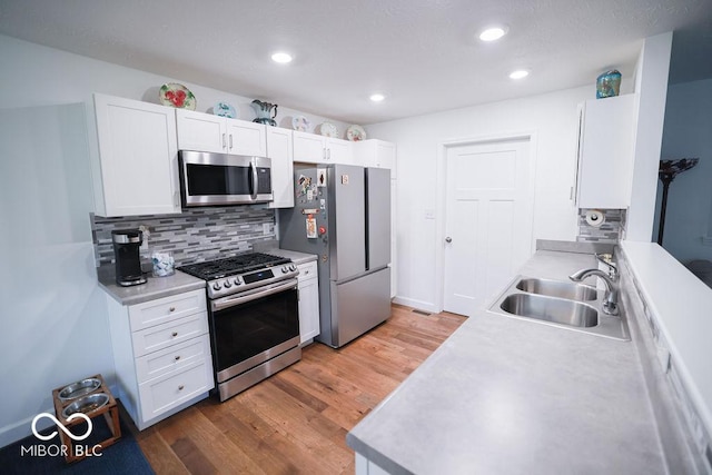 8917 N Old State Road 37, Bloomington, IN 47408 - kitchen featuring tasteful backsplash, white cabinets, wood finished floors, a sink, and stainless steel appliances