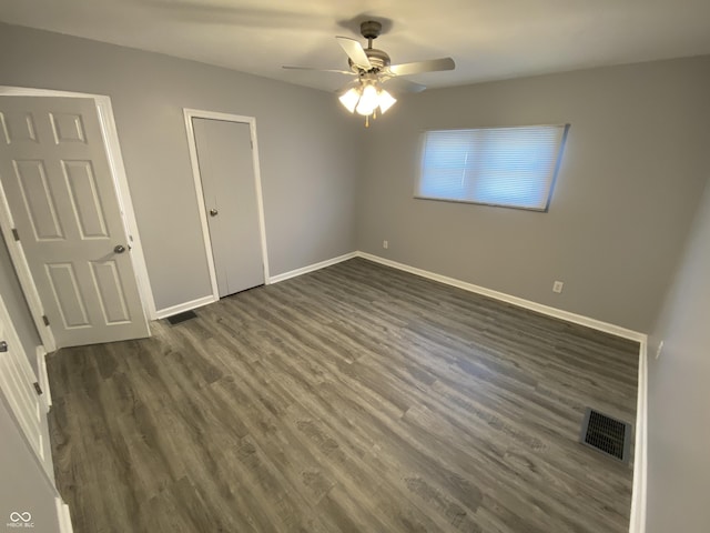 1546 Kappes St, Indianapolis, IN 46221 - unfurnished bedroom with visible vents, baseboards, a ceiling fan, and dark wood-style floors