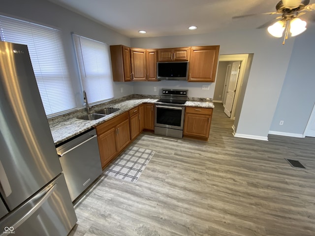 1546 Kappes St, Indianapolis, IN 46221 - kitchen featuring visible vents, a sink, appliances with stainless steel finishes, light wood finished floors, and light stone counters